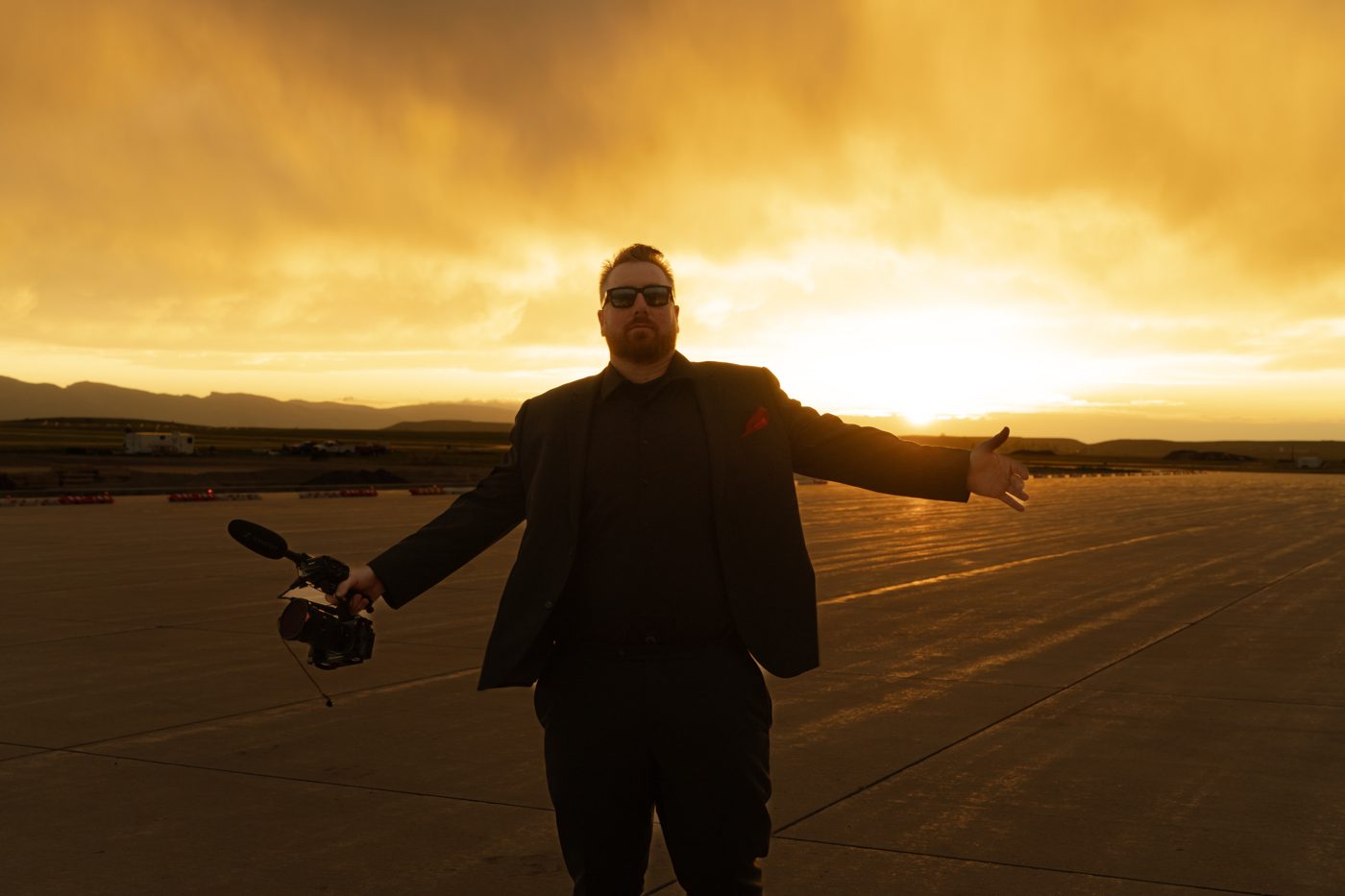 Mike Ask, founder of Coach Mike Entertainment, at sunset with camera in hand