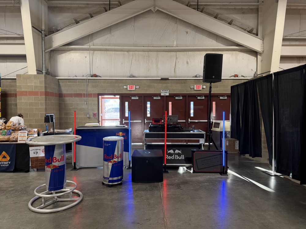 DJ setup with red and blue LED pillars at a Red Bull USA vendor event